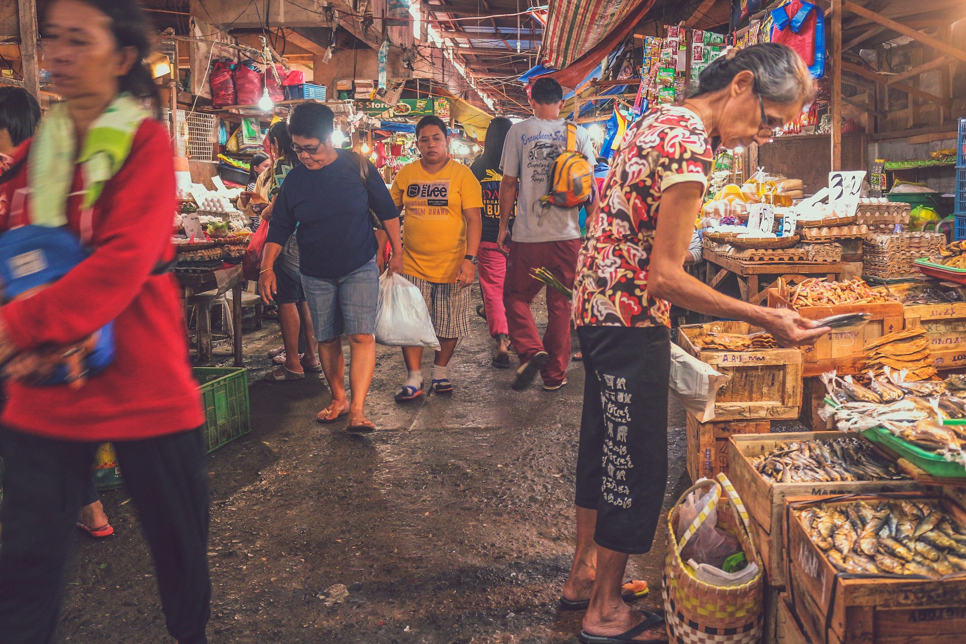 Shoppers moving through the covered aisles of a busy Philippine public market